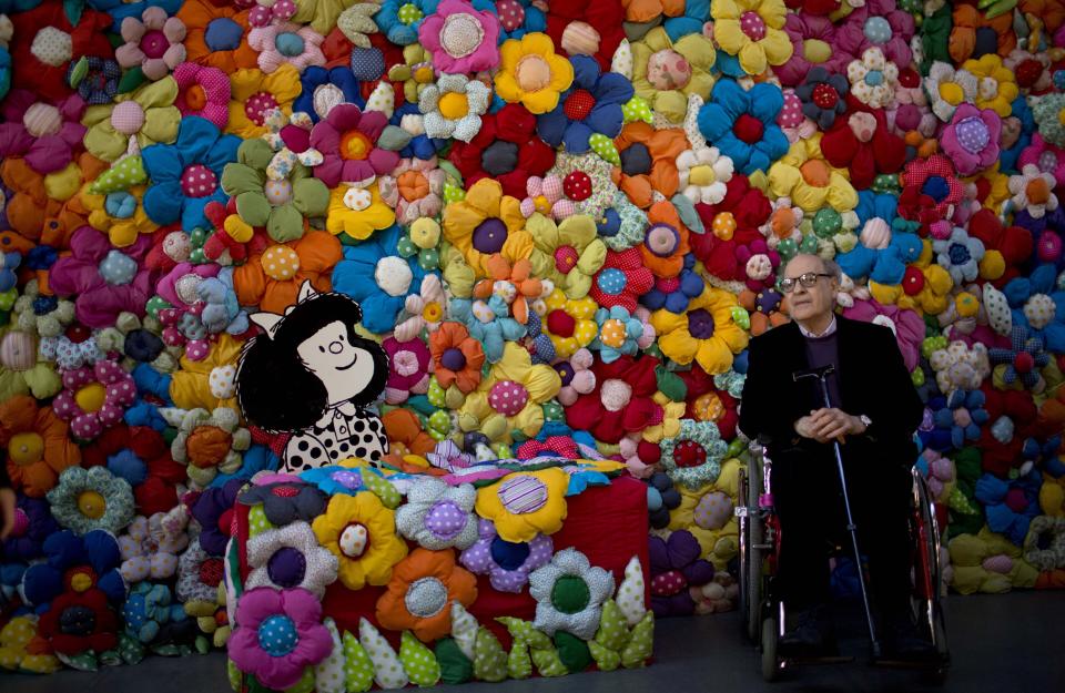 FILE - In this Sept. 15, 2014 file photo, Argentine cartoonist Joaquin Salvador Lavado, better known as "Quino," poses next to his character Mafalda at the exhibition, The World According to Mafalda, in Buenos Aires, Argentina. Lavado passed away on Wednesday, Sept. 30, 2020, according to his editor Daniel Divinsky who announced it on social media. (AP Photo/Natacha Pisarenko, File)