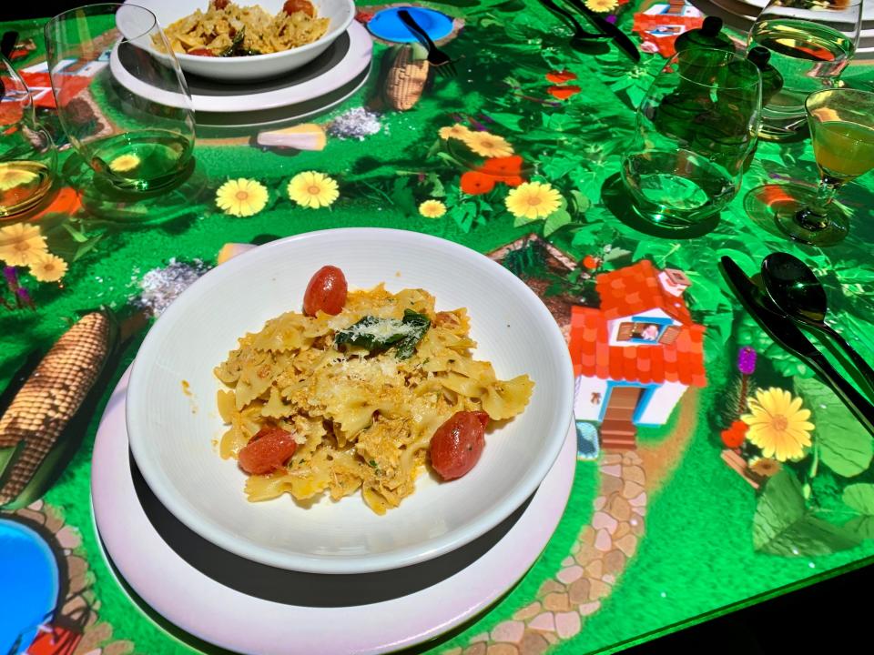 a plate of pasta above a table with projected animations