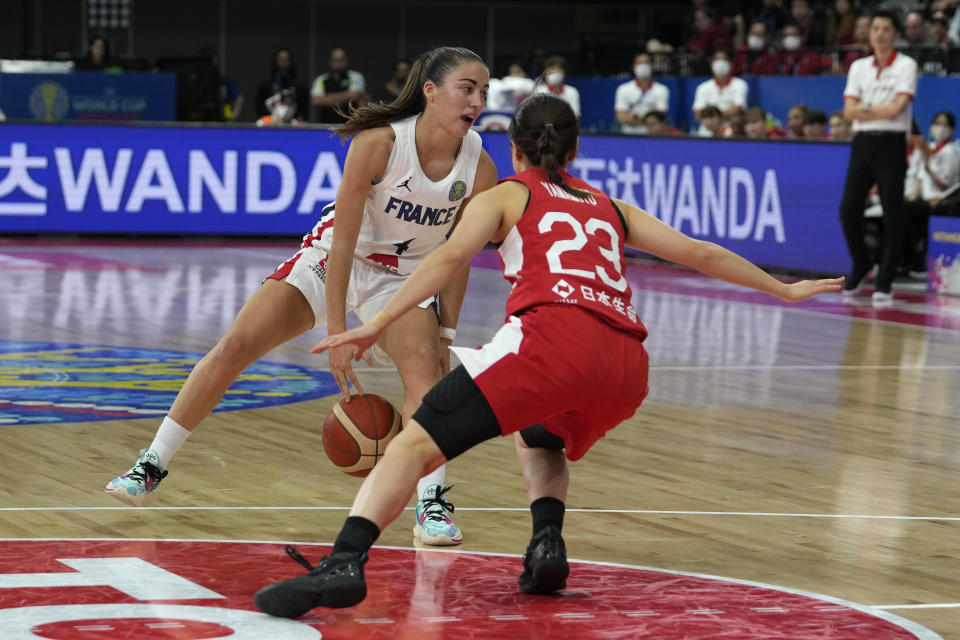 France's Marine Fauthoux, left, dribbles the ball through her legs in front of Japan's Mai Yamamoto during their game at the women's Basketball World Cup in Sydney, Australia, Monday, Sept. 26, 2022. (AP Photo/Rick Rycroft)