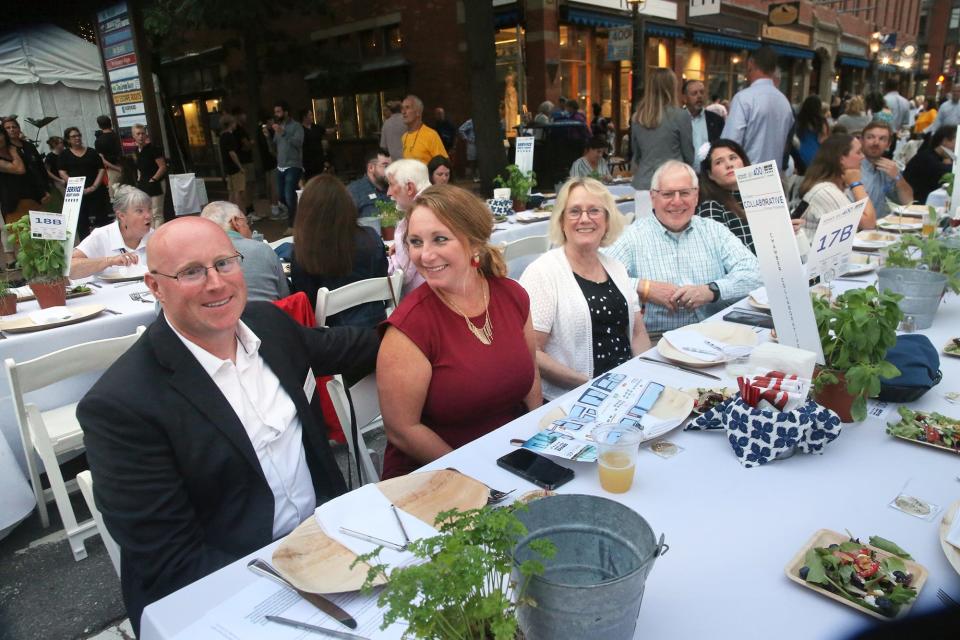 President of the Chamber Collaborative of Greater Portsmouth, Ben VanCamp, left, sits with his wife and parents during a 900-person lobster dinner served the length of Congress Street in celebration of the city's 400th anniversary Wednesday, Aug.16, 2023.