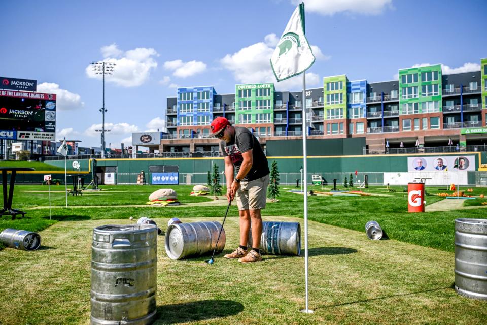 Head Lugnuts groundskeeper Joe Trautner plays a hole at the 18-hole golf course on the baseball field after getting it prepared for visitors on Thursday, Sept. 19, 2024, at Jackson Field in Lansing. The 18-hole miniature golf course is open to the public through Sunday.