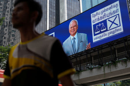 A man walks past an advertising screen showing Malaysia's Prime Minister Najib Razak and his ruling Barisan Nasional party in Kuala Lumpur, Malaysia, May 7, 2018. REUTERS/Athit Perawongmetha