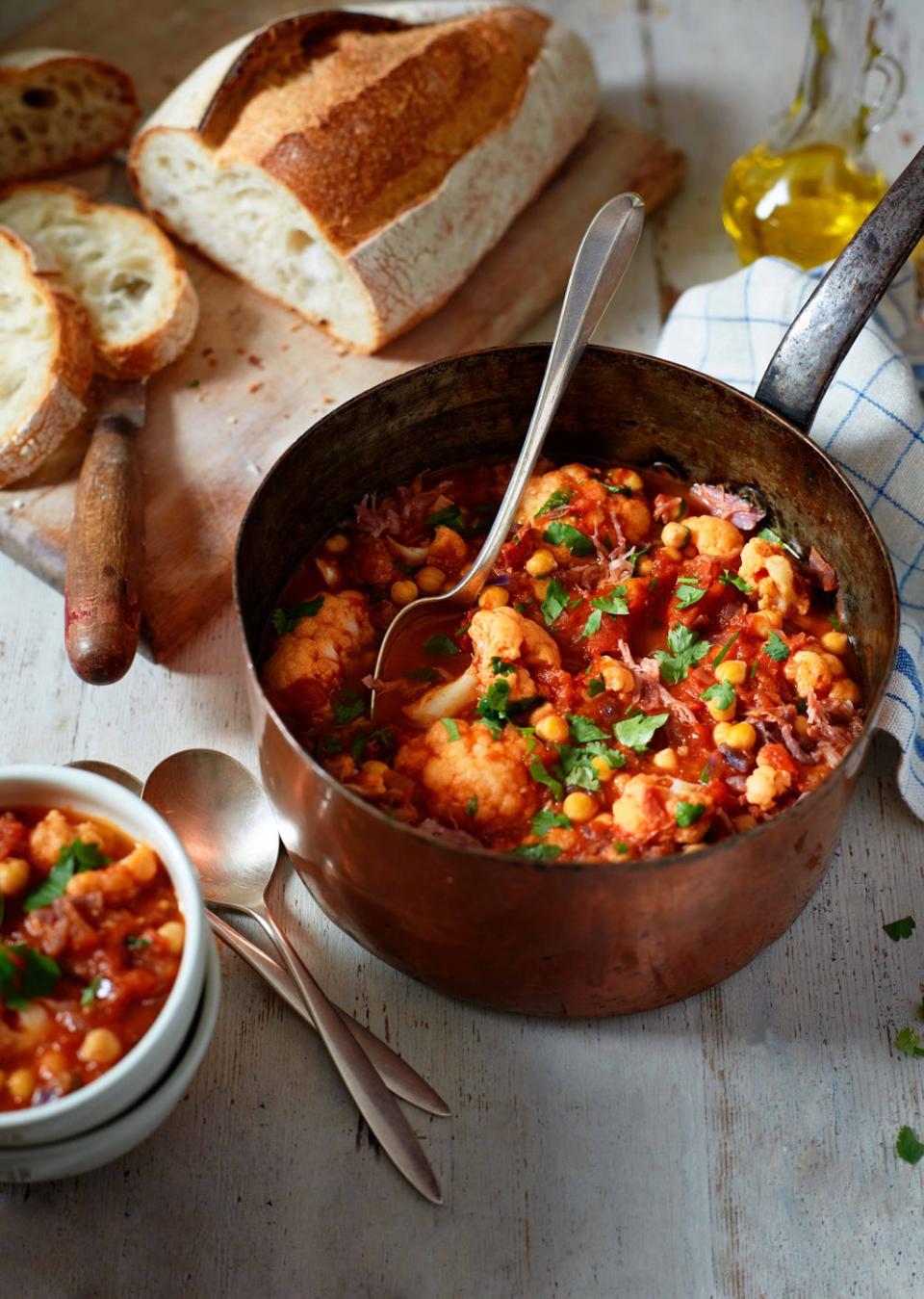 a bowl of soup with bread and a spoon