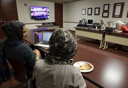 University of California Irvine student Huda Herwees (L), 19, and University of California Riverside student Amal Ali (2nd L), 22, watch the Republican presidential debate with other students at the Council on American-Islamic Relations (CAIR) office in Anaheim, California December 15, 2015. REUTERS/Jason Redmond