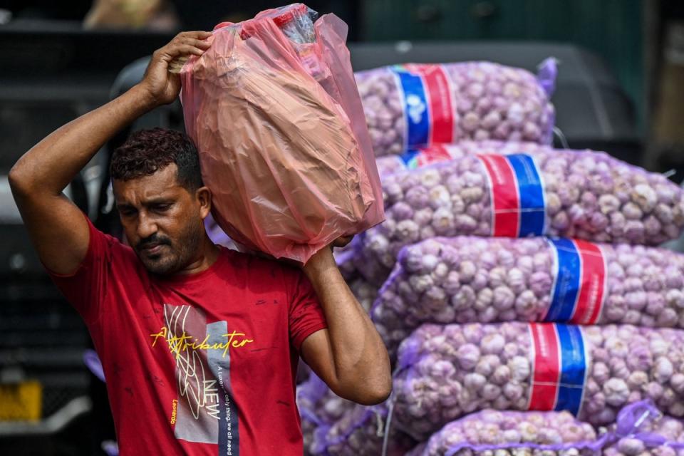 Workers transport essential goods at a market in Colombo last month (AFP via Getty Images)