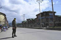 A security personnel wearing a facemask stands guard along a deserted street during a one-day nationwide Janata (civil) curfew imposed as a preventive measure against the COVID-19 coronavirus, in Srinagar on March 22, 2020. - Nearly one billion people around the world were confined to their homes, as the coronavirus death toll crossed 13,000 and factories were shut in worst-hit Italy after another single-day fatalities record. (Photo by Tauseef MUSTAFA / AFP) (Photo by TAUSEEF MUSTAFA/AFP via Getty Images)