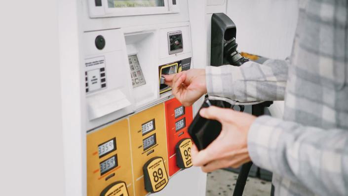 Close-up of unrecognizable white male man purchasing gas at pump