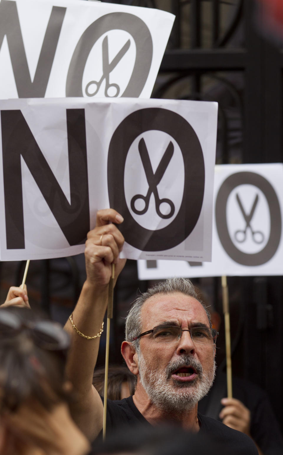 A demonstrator shouts outside the Finance Ministry as civil servants protest, in Madrid Friday Aug. 10. 2012. The Spanish Parliament approved in July parts of a euro 65 billion austerity package that includes cuts in pay for civil servants. Prime Minister Mariano Rajoy is fighting to prevent Spain becoming the latest and biggest victim of the economic crisis crippling the 17 countries that use the euro and ask for a full-blown government bailout. (AP Photo/Paul White)