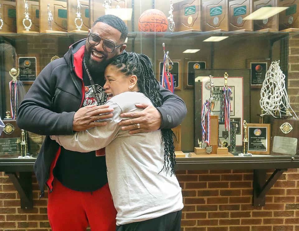Buchtel  boys basketball head coach Rayshon Dent get a hug from school intervention specialist Clara Blackwell during a school assembly celebrating the team's Division II state championship, Wednesday, March 22, 2023.
