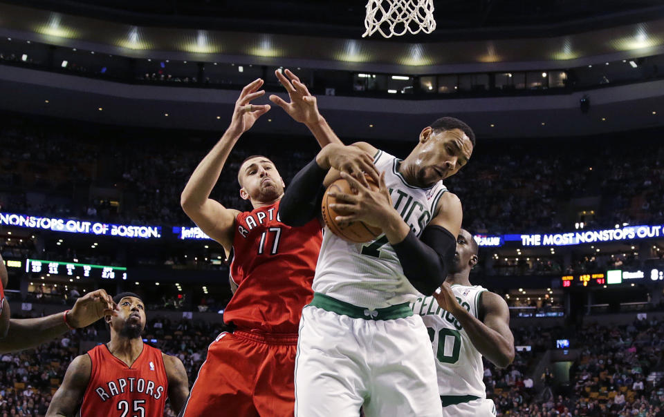 Boston Celtics forward Jared Sullinger, right, hauls down a rebound against Toronto Raptors center Jonas Valanciunas (17) during the during the second quarter of an NBA basketball game in Boston, Wednesday, Jan. 15, 2014. (AP Photo/Charles Krupa)