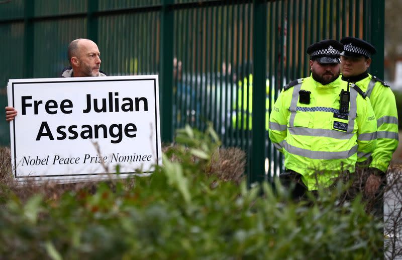 Un hombre sostiene un cartel frente al Tribunal de la Corona de Woolwich, antes de una audiencia para decidir si Julian Assange debe ser extraditado a los Estados Unidos, en Londres, Reino Unido