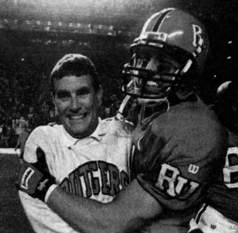 Terry Shea gets a hug from wide receiver Andy Holland after Rutgers beat Army 27-12 on Saturday, Sept. 26, 1998.