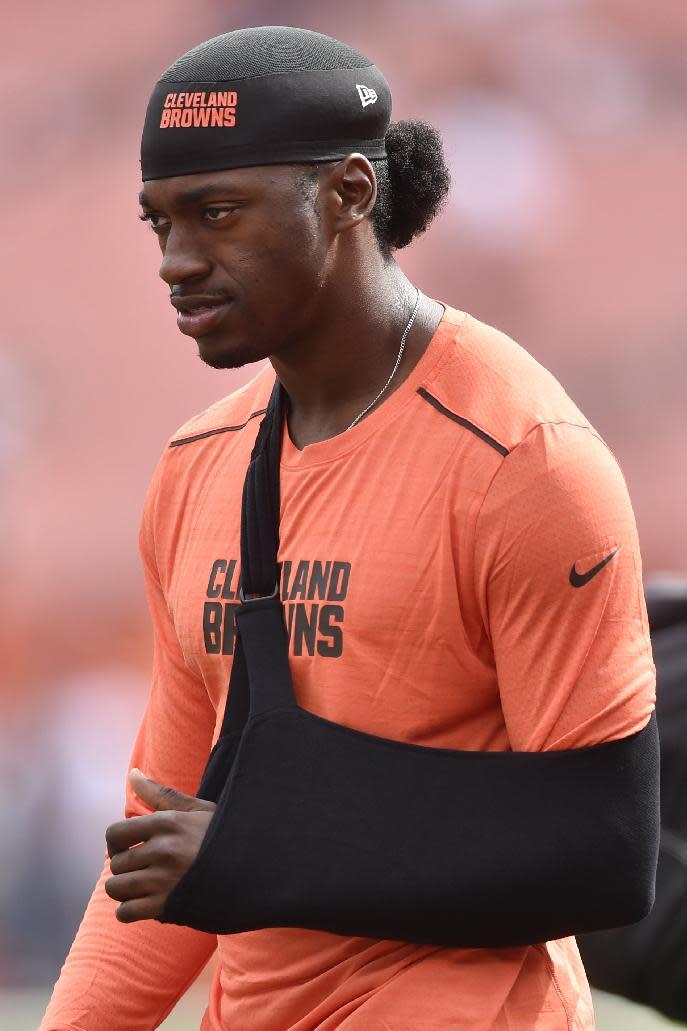 FILE - In this Sept. 18, 2016, file photo, Cleveland Browns quarterback Robert Griffin III walks the field during practice with his arm in a sling before an NFL football game against the Baltimore Ravens, in Cleveland. A person familiar with the decision says the Browns are releasing quarterback Robert Griffin III after one injury-marred season. Griffin is being let go one day before he would have been due a $750,000 roster bonus, said the person who spoke Friday, March 10, 2017, to the Associated Press on condition of anonymity because the team has not announced the move. (AP Photo/David Richard, File)