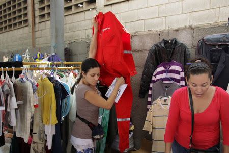 A woman carries a PDVSA's overall for sale at a market in Maracaibo, Venezuela September 11, 2016. REUTERS/Jesus Contreras