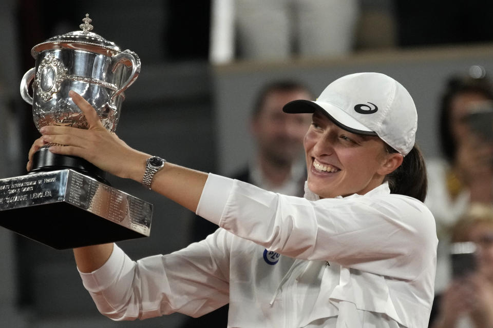 Poland's Iga Swiatek presents the cup after defeating Coco Gauff of the U.S. in the women final match of the French Open tennis tournament at the Roland Garros stadium Saturday, June 4, 2022 in Paris. Swiatek won 6-1, 6-3. (AP Photo/Christophe Ena)