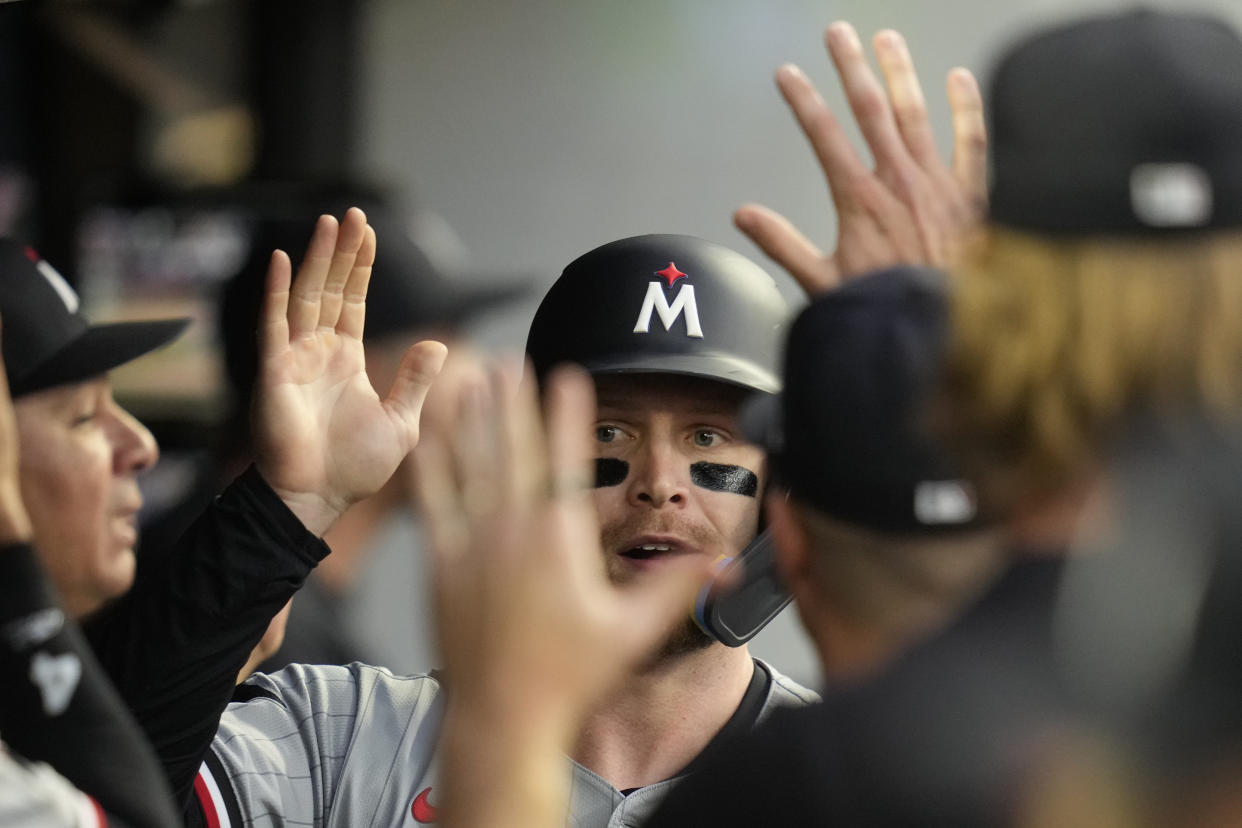 Minnesota Twins' Ryan Jeffers, center, gets high-fives in the dugout after scoring in the third inning of a baseball game against the Cleveland Guardians, Monday, Sept. 16, 2024, in Cleveland. (AP Photo/Sue Ogrocki)