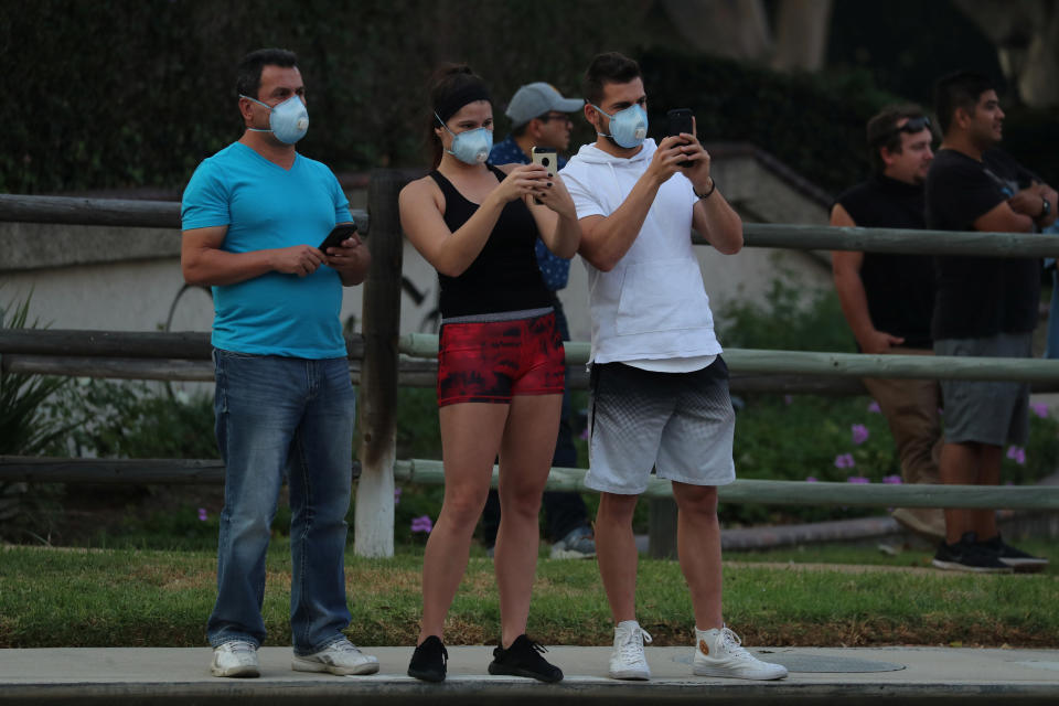 Residents use their phones to record firefighters in Orange, California.&nbsp;