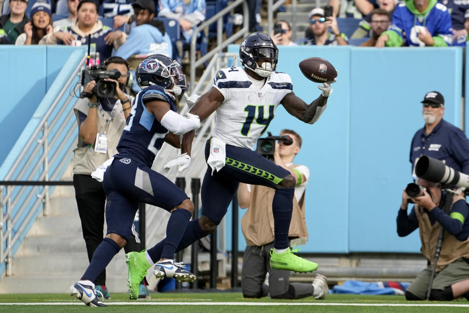 Seattle Seahawks wide receiver DK Metcalf (14) catches a touchdown pass in front of Tennessee Titans cornerback Tre Avery during the second half of an NFL football game on Sunday, Dec. 24, 2023, in Nashville, Tenn. (AP Photo/George Walker IV)