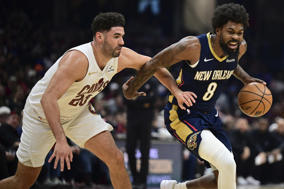 New Orleans Pelicans forward Naji Marshall drives on Cleveland Cavaliers forward Georges Niang during the first half of an NBA basketball game Thursday, Dec. 21, 2023, in Cleveland. (AP Photo/David Dermer)