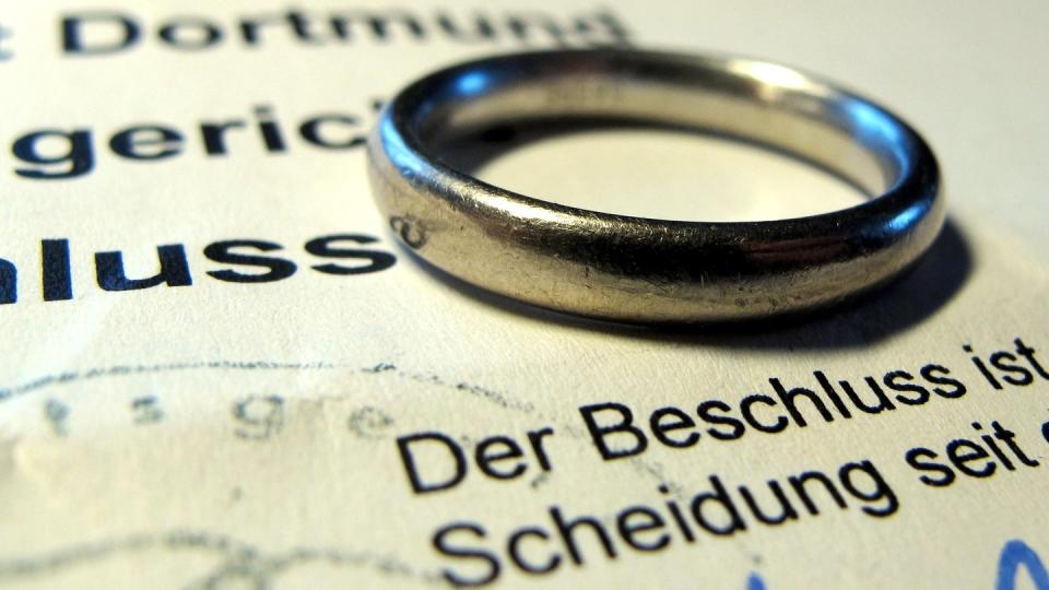 Ehering auf einem Gerichtsbeschluss über eine Scheidung. Rund rund 149.000 Ehen wurden im vergangenen Jahr geschieden.