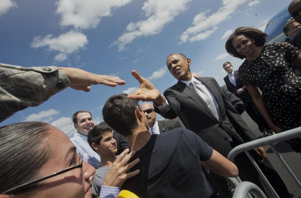 President Barack Obama and first lady Michelle Obama greet members of the military on the tarmac upon their arrival at Homestead Air Reserve Base, Friday, March 7, 2014, in Homestead, Fla. Obama and the first lady traveled to Miami and will visit a local high school to unveil a new initiative program to ensure more students complete the Free Application for Federal Student Aid (FAFSA), a document required by most types of financial aid such as Pell grants. (AP Photo/Pablo Martinez Monsivais)