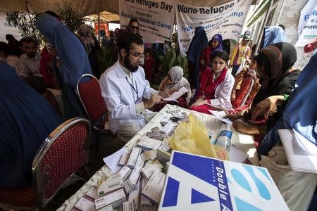 Afghan refugees wait to have a medical check-up at a health clinic setup by the United Nations High Commissioner for Refugees (UNHCR) to mark World Refugee Day in Islamabad June 20, 2014. REUTERS/Faisal Mahmood