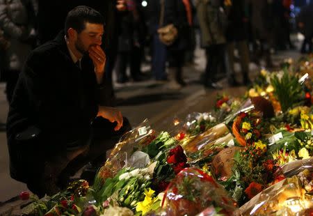 A man observes a moment of silence at a memorial for the victims of the deadly attacks in front of the synagogue in Krystalgade in Copenhagen, February 15, 2015. REUTERS/Leonhard Foeger