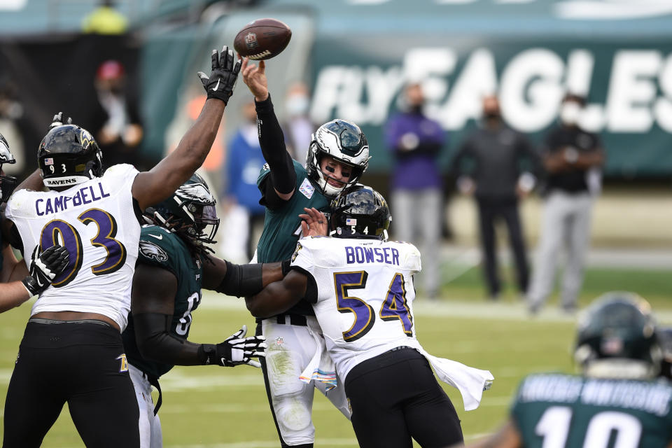 Philadelphia Eagles' Carson Wentz (11) tries to pass against Baltimore Ravens' Tyus Bowser (54) and Calais Campbell (93) during the second half of an NFL football game, Sunday, Oct. 18, 2020, in Philadelphia. (AP Photo/Derik Hamilton)