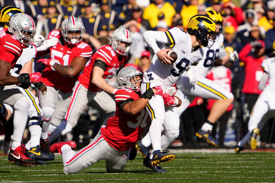 Nov 26, 2022; Columbus, Ohio, USA;  Ohio State Buckeyes linebacker Cody Simon (30) tries to tackle Michigan Wolverines quarterback J.J. McCarthy (9) during the first half of the NCAA football game at Ohio Stadium. Mandatory Credit: Adam Cairns-The Columbus Dispatch