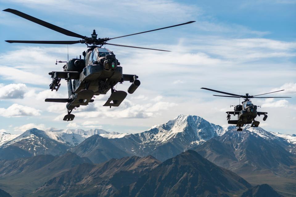 AH-64D Apache Longbow attack helicopters fly over a mountain range near Fort Wainwright, Alaska, on June 3, 2019.