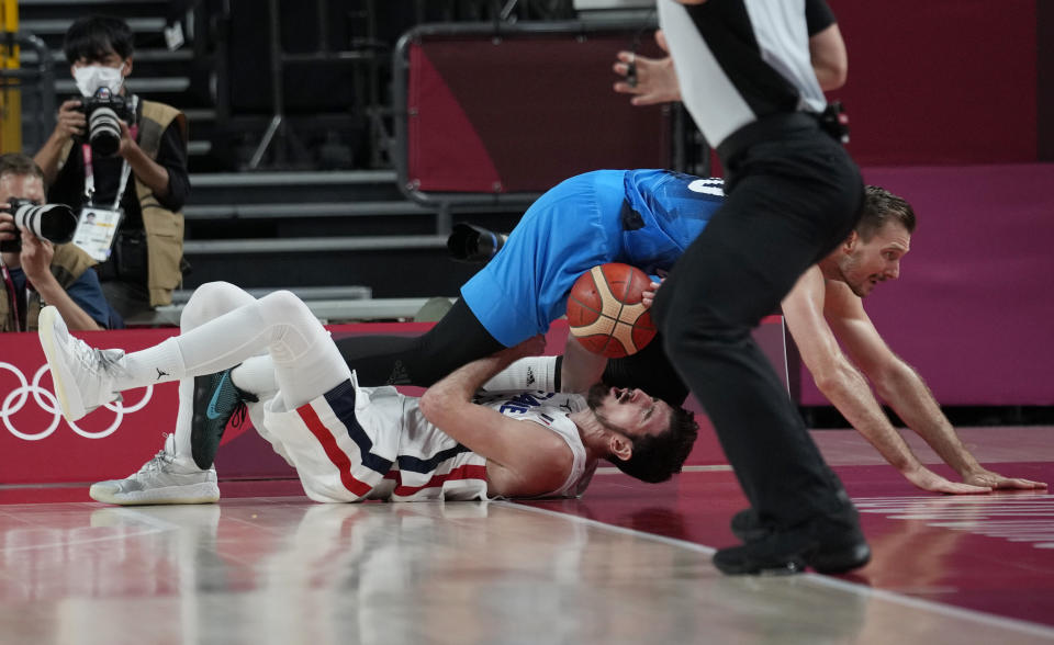 Slovenia's Zoran Dragic, top, crashes into France's Nando de Colo, bottom, during a men's basketball semifinal round game at the 2020 Summer Olympics, Thursday, Aug. 5, 2021, in Saitama, Japan. (AP Photo/Eric Gay)