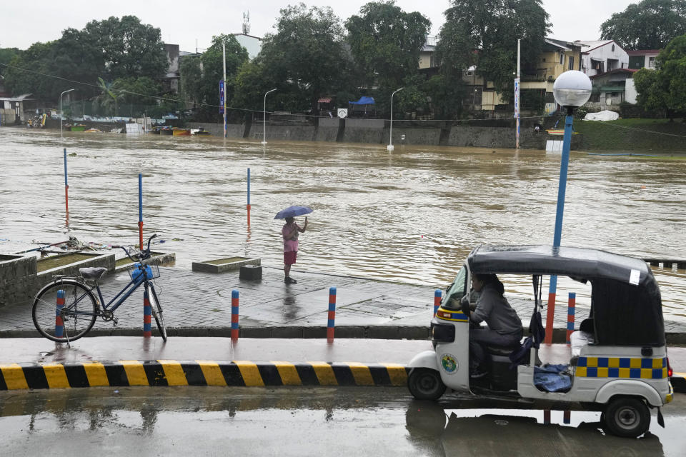 A man takes a picture of a swollen river due to enhanced rains brought about by Typhoon Doksuri on Thursday, July 27, 2023, in Marikina city, Philippines. Typhoon Doksuri lashed northern Philippine provinces with ferocious wind and rain Wednesday, leaving several people dead and displacing thousands of others as it blew roofs off houses, flooded low-lying villages and triggered dozens of landslides, officials said. (AP Photo/Aaron Favila)