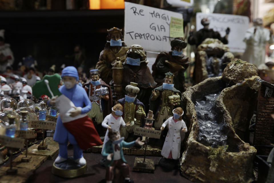 Statuette of the Three Wise Men with face masks are displayed at a nativity scenes shop in San Gregorio Armeno street in Naples, in the region of Campania, Italy, Friday, Nov. 13, 2020. The regions of Campania and Tuscany were designated red zone on Friday, signaling the dire condition of a hospitals struggling with a surge of new admissions. (AP Photo/Gregorio Borgia)