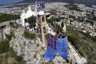 Anti-EU protesters hang a banner from Lycabettus hill in Athens, Greece, July 2, 2015. REUTERS/Antonis Nikolopoulos/Eurokinissi