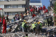 Members of rescue services search for survivors in the debris of a collapsed building in Izmir, Turkey, Saturday, Oct. 31, 2020. Rescue teams on Saturday ploughed through concrete blocs and debris of eight collapsed buildings in Turkey's third largest city in search of survivors of a powerful earthquake that struck Turkey's Aegean coast and north of the Greek island of Samos, killing dozens Hundreds of others were injured. (AP Photo/Darko Bandic)