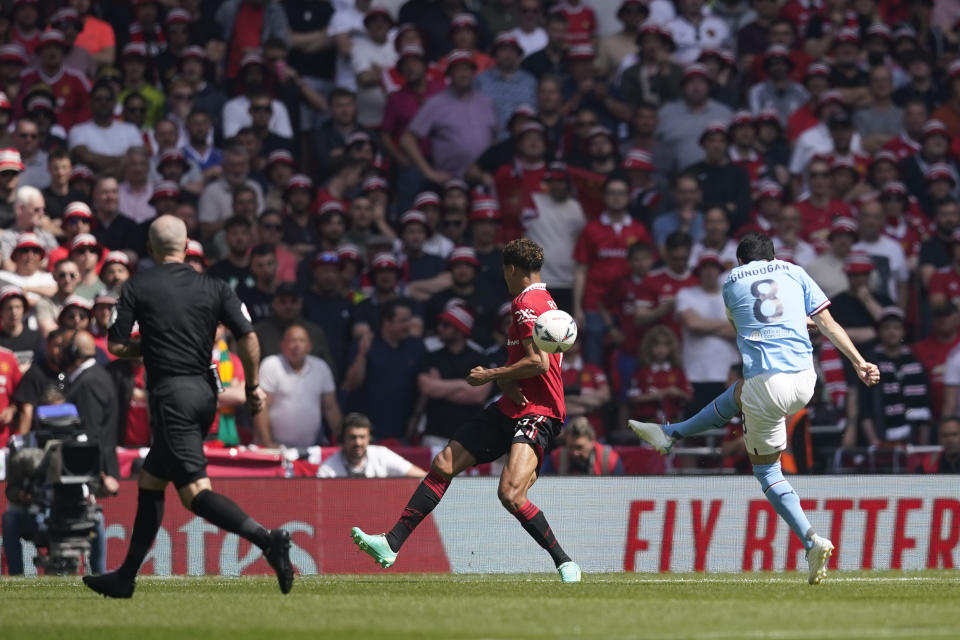 Manchester City's Ilkay Gundogan, right, scores his side's opening goal during the English FA Cup final soccer match between Manchester City and Manchester United at Wembley Stadium in London, Saturday, June 3, 2023. (AP Photo/Dave Thompson)