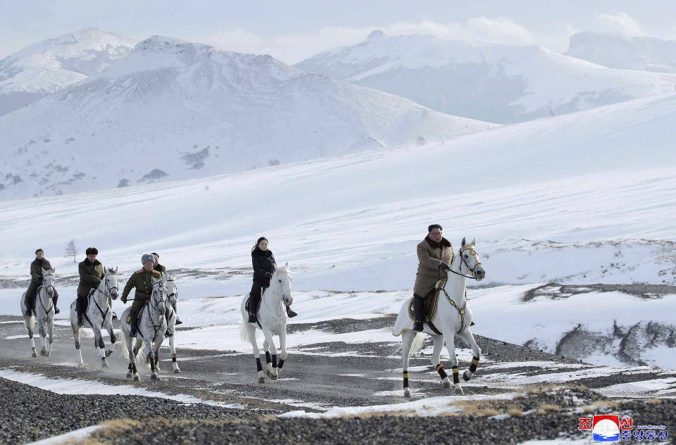 This undated photo provided on Wednesday, Dec. 4, 2019, by the North Korean government shows North Korean leader Kim Jong Un, right, and his wife Ri Sol Ju, second from right, riding on white horse during a visit to Mount Paektu, North Korea. North Korea says leader Kim has taken a second ride on a white horse to a sacred mountain in less than two months. Independent journalists were not given access to cover the event depicted in this image distributed by the North Korean government. The content of this image is as provided and cannot be independently verified. Korean language watermark on image as provided by source reads: "KCNA" which is the abbreviation for Korean Central News Agency. (Korean Central News Agency/Korea News Service via AP)