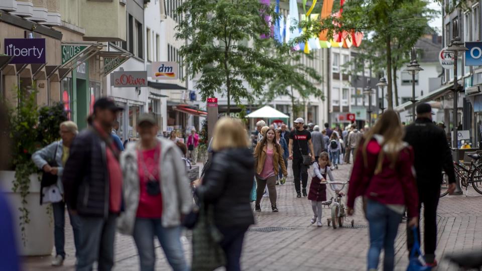 Menschen in einer Einkaufszone in der Berliner Straße in der Innenstadt von Gütersloh.