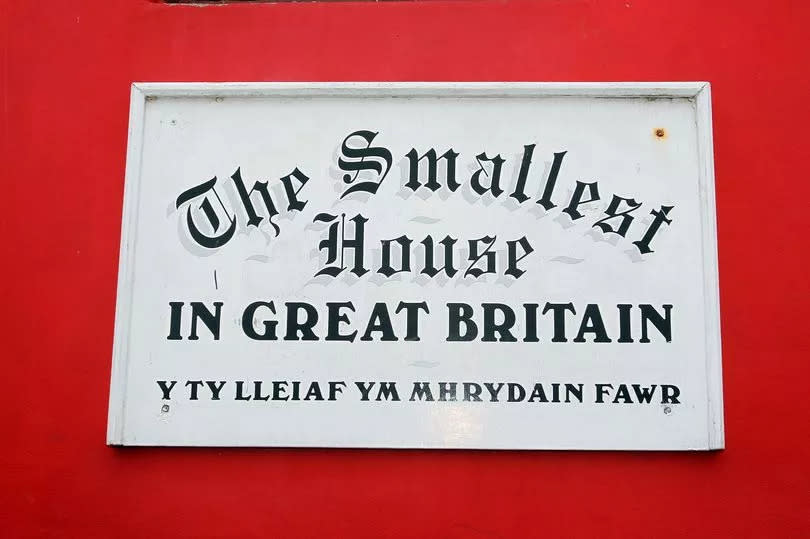 A sign proclaiming the building as The Smallest House in Great Britain on Conwy Quay.