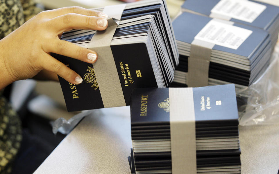 A worker gets more passport books as she works to reduce the passport backlog at the New Orleans Passport Agency in New Orleans. (AP Photo/Alex Brandon)