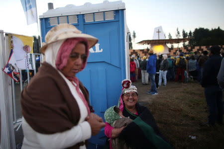 A faithful from Mapuche ethnic group smiles as she waits for Pope Francis to lead a mass at the Maquehue Temuco Air Force base in Temuco, Chile, January 17, 2018. REUTERS/Edgard Garrido