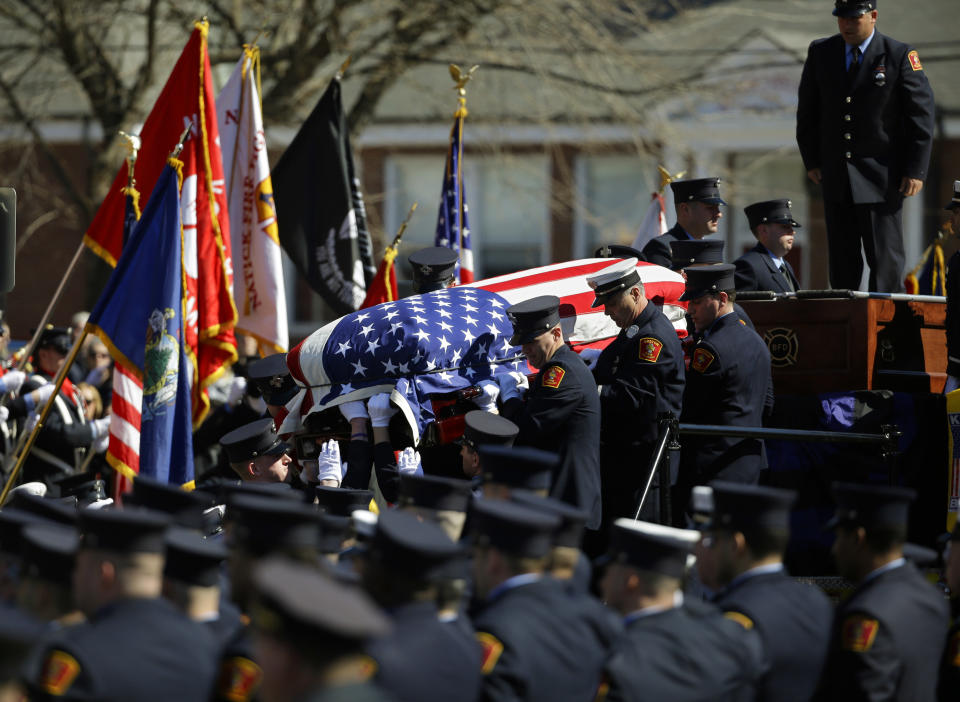 The casket containing the body of Boston firefighter Michael R. Kennedy is carried off his fire truck before his funeral outside Holy Name Church in Boston, Thursday, April 3, 2014. Kennedy and Boston Fire Lt. Edward J. Walsh were killed Wednesday, March 26, 2014 when they were trapped in the basement of a burning brownstone during a nine-alarm blaze.(AP Photo/Stephan Savoia)