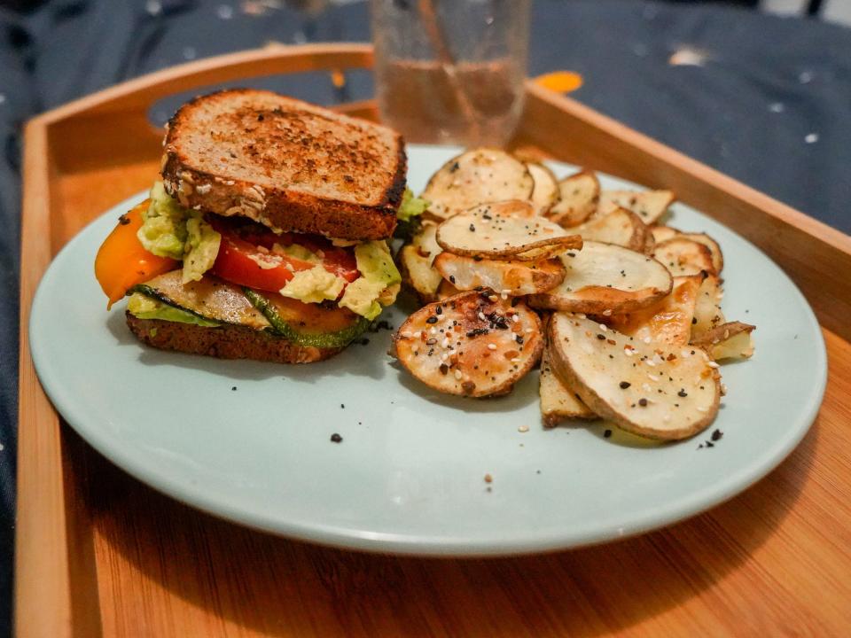 Sandwich with avocado, tomato, seared bell pepper and zucchini, and "fries."