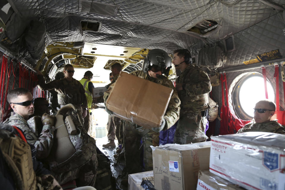 In this Monday, Dec. 23, 2019, photo, U.S. soldiers load Christmas gifts onto a helicopter in Irbil, Iraq bound for American bases in eastern Syria. It's an operation is called Holiday Express - in addition to delivering presents, the U.S.-led coalition forces brought a U.S. military band to play Christmas carols and music to several bases in eastern Syria. (AP Photo/Farid Abdul-Wahid)