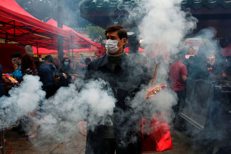 Worshippers wear masks to prevent an outbreak of a new coronavirus as they make offerings of incense sticks during a Lunar New Year celebration at Che Kung Temple, in Hong Kong