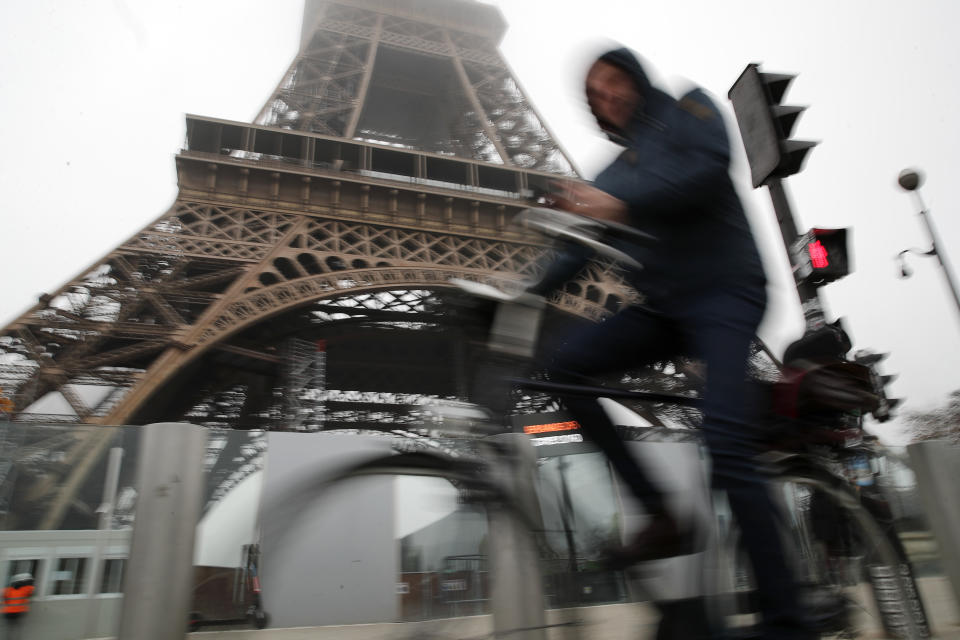 A man rides his bicycle in front of the closed Eiffel Tower in Paris, Thursday, Dec. 5, 2019. The Eiffel Tower shut down Thursday, France's vaunted high-speed trains stood still and teachers walked off the job as unions launched nationwide strikes and protests over the government's plan to overhaul the retirement system. (AP Photo/Francois Mori)