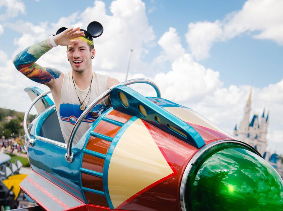 A man on the The Astro Orbiter with disney in the background