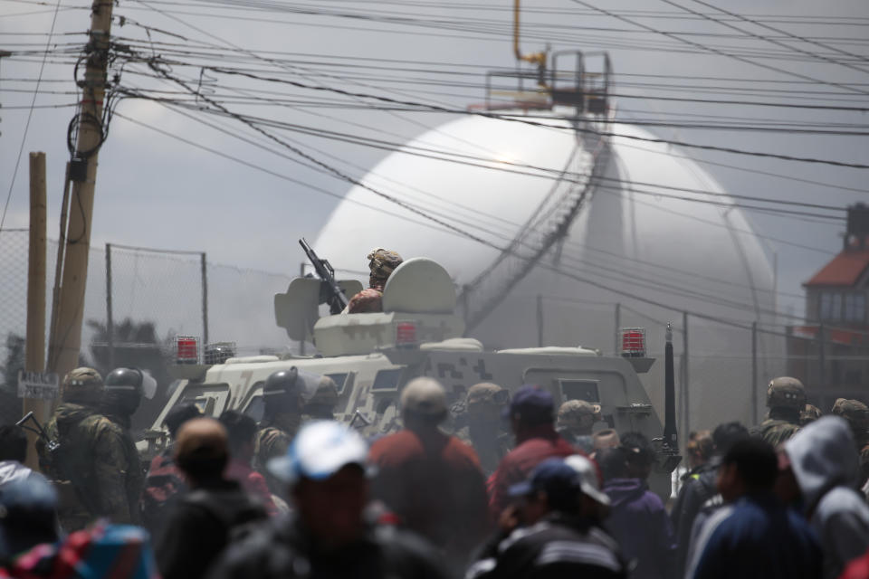 Soldiers guard the perimeters of the state-own Senkata filling plant, as supporters of former President Evo Morales gather round, in El Alto, on the outskirts of La Paz, Bolivia, Tuesday, Nov. 19, 2019. Morales' backers have taken to the streets asking for his returns since he resigned on Nov. 10 under pressure from the military after weeks of protests against him over a disputed election he claim to have won. (AP Photo/Natacha Pisarenko)