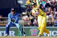 Australia's Steve Smith (R) hits a six as India's wicketkeeper MS Dhoni looks on during the One Day International cricket match in Perth January 12, 2016. REUTERS/Bill Hatto