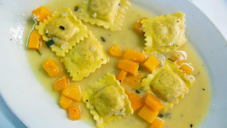 Gourmet butternut squash ravioli, a gourmet Italian food on a white plate at an upscale restaurant.